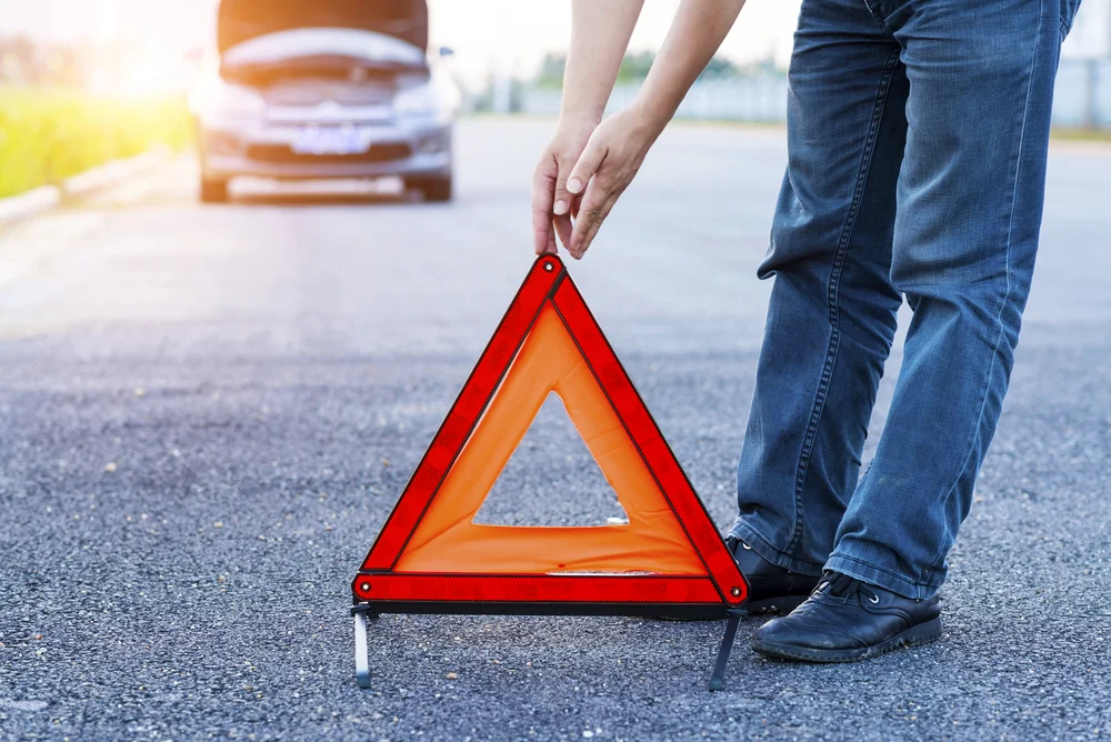 Mann, der rotes Notstoppschild auf der Straße platziert